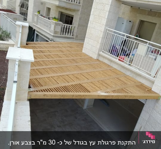 פרגולה מעץ מעל מרפסת עם רצפת אריחים אפורים